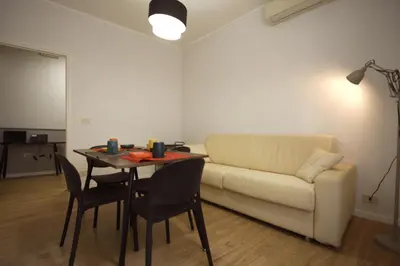 a living room with a couch and a table with chairs at Vascello Holiday House in Rome