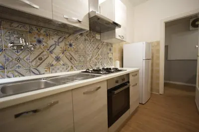 a kitchen with a sink stove and a refrigerator at Vascello Holiday House in Rome