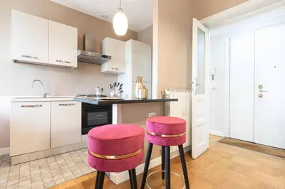 a kitchen with two pink stools in front of a counter at Colosseo Terrace Apartment in Rome