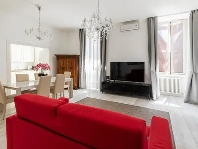 a living room with a red couch and a dining room at FCR Rome Apartments Gracchi Vatican in Rome