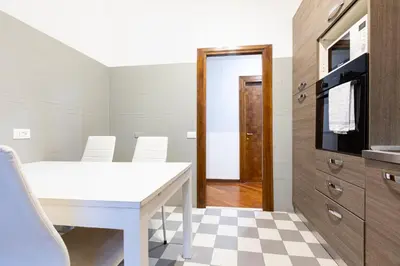 a dining room with a white table and a tv at Amazing Art Déco Apartment Pantheon in Rome