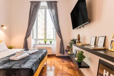 a bedroom with a bed and a flat screen tv at Appartamento Principe Amedeo in Rome