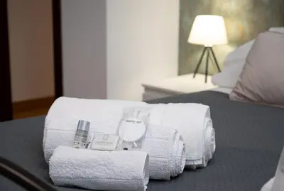 a hotel room with towels and a bottle of perfume at Residenza Lualdi in Rome