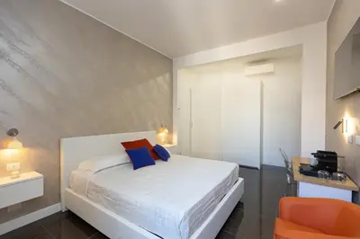 a bedroom with a white bed and an orange chair at KOSMO ROME Luxury in Rome