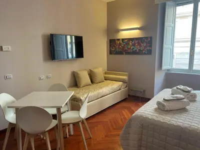 a living room with a couch and a table and a tv at Dolce Vita Guest House in Rome