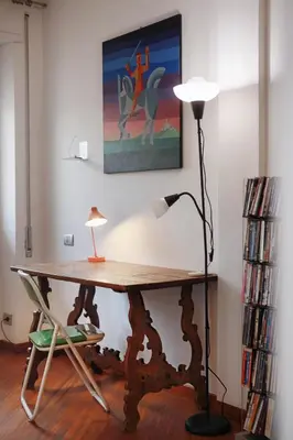 a desk with a lamp and a chair in a room at Appartamento Trastevere & Porta Portese grande in Rome