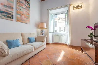 a living room with a couch and a window at Barberini 3 BDR Apartment in Rome