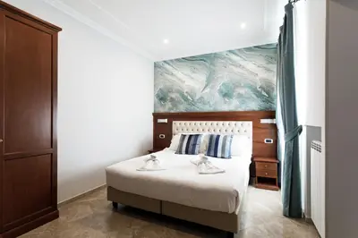 a bedroom with a bed with a painting on the wall at Esposizione Luxury Rome in Rome
