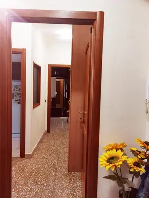 a hallway with a door and flowers in a vase at Appartamento per Turisti e Famiglie Roma in Rome