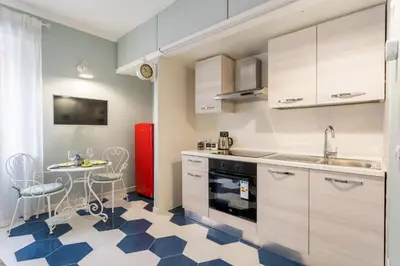 a kitchen with white cabinets and a blue and white floor at The small nest at Coliseum in Rome