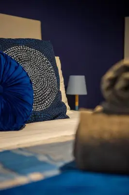 a bed with a blue and white pillow on it at Holiday Homes Rome - Portuense 21 - Family Studio in Rome