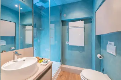 a bathroom with blue walls and a sink and a toilet at Design apt near Spanish Step in Rome
