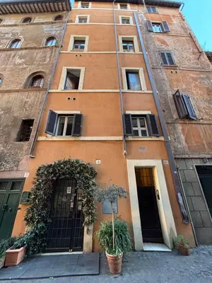 an orange building with two doors and a plant at Casa Uberto in Rome