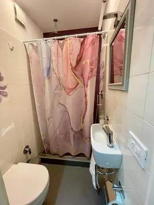 a bathroom with a pink shower curtain and a sink at PRIVATEHOUSEINROME in Rome