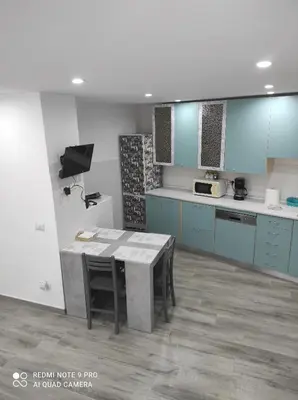 a kitchen with blue cabinets and a table with chairs at Casa Mario in Rome