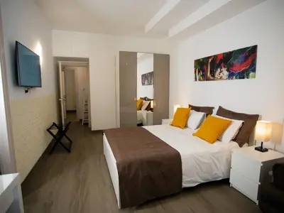 a bedroom with a large bed with yellow pillows at Anastasio Vatican Rooms G H in Rome