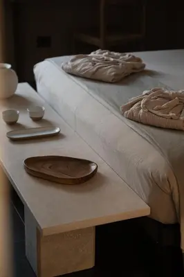 two wooden plates on a table next to a bed at The Sanctuary Urban Retreat in Rome