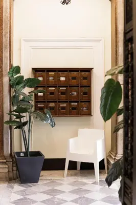 a white chair and a plant in a room at Esposizione Boutique in Rome