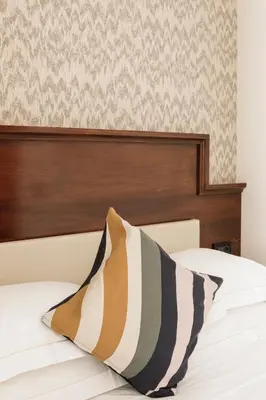a bed with a wooden headboard and a pillow at Esposizione Boutique in Rome