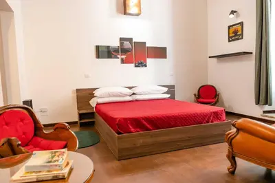 a bedroom with a bed and a chair and a table at MyWay Colosseo Apartment in Rome