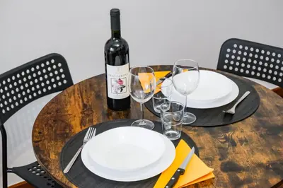 a wooden table with a bottle of wine and glasses at St. Peter Vatican Home in Rome