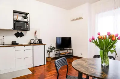 a kitchen and dining room with a table and flowers at St. Peter Vatican Home in Rome