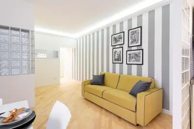 a living room with a yellow couch and striped wall at VRhome in Rome