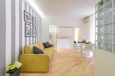 a living room with a yellow couch and a table at VRhome in Rome