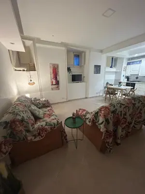 a living room with two beds and a table at Home in Trastevere Testaccio in Rome