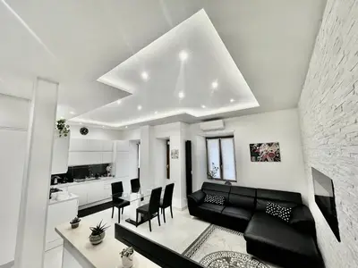 a living room with a black couch and a table at ZAMA HOME in Rome