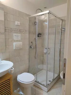 a bathroom with a shower with a toilet and a sink at Bosuites Rome in Rome