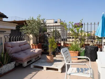 a couch and two chairs on a patio at Terrace Apartment On The Monuments Of Rome in Rome