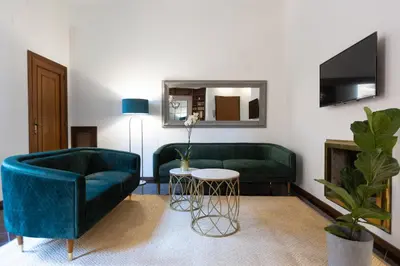 a living room with two green couches and a table at Borgo Terrace by Rental in Rome in Rome