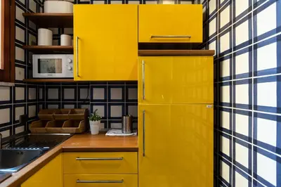 a yellow refrigerator in a kitchen with yellow cabinets at Borgo Terrace by Rental in Rome in Rome