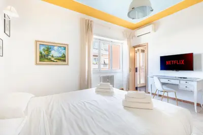 a white bedroom with a white bed and a desk at Gregorio VII - Deliziosa sistemazione a due passi da San Pietro in Rome