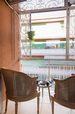 a balcony with two chairs and a table and a window at Gregorio VII - Deliziosa sistemazione a due passi da San Pietro in Rome