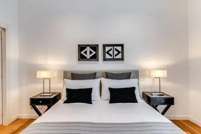 a bedroom with a large white bed with two lamps at Charming flat by the Vatican in Rome