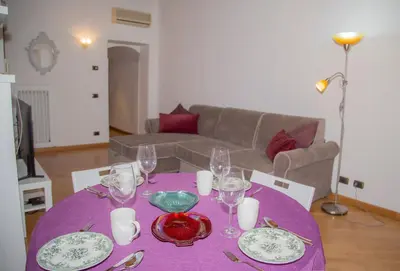 a table with plates and glasses on a purple table cloth at sweet home Laurina in Rome