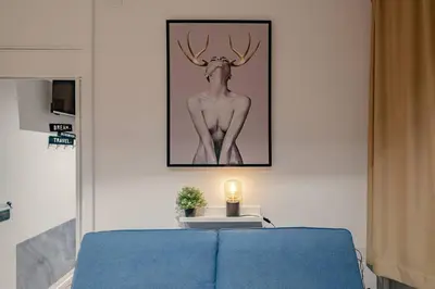 a room with a blue couch and a picture of a deer at Modern Apartment at San Giovanni in Rome