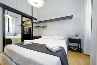 a large bedroom with two beds and a mirror at 4BNB - Spacious Porta Pia Apartment in Rome