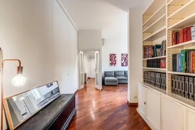 a living room with a couch and bookshelves at Splendid flat on the Tiber river in Rome