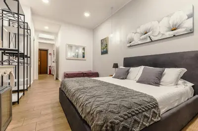 a white bedroom with a white bed and a shelf at Prati Sweet Home in Rome