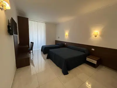 a hotel room with two beds and a television at Giovanni Guest House in Rome