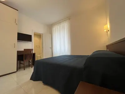 a bedroom with a bed and a desk in it at Giovanni Guest House in Rome