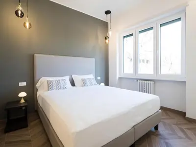a bedroom with a large white bed and two windows at Savoia Rooms Roma in Rome