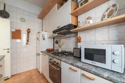 a kitchen with a stove and a microwave at GuestHost - San Giovanni in Laterano Comfy Apartment in Rome