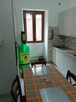 a kitchen with a table with a bottle of wine at Pigneto House in Rome