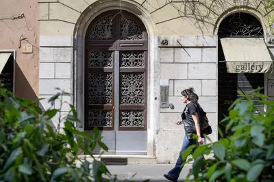 a woman walking in front of a building with a door at Casa Violante Luxury Apartment in Rome