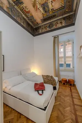 a bedroom with a white bed with a ceiling at Appartamento storico in zona Barberini in Rome