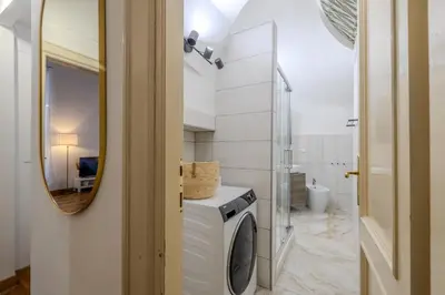 a bathroom with a washing machine and a mirror at Appartamento storico in zona Barberini in Rome